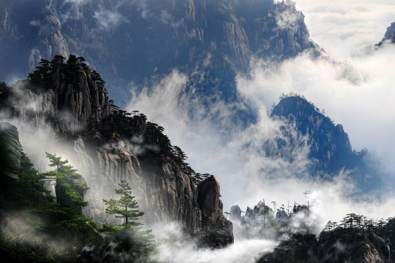 Dramatic misty mountains of Anhui, China — karst peaks emerging through cloud layers
